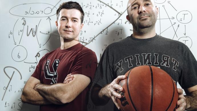 数学 professors Brian Miceli and Cabral Balreira behind a marked-up glass wall