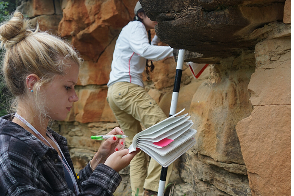 Student Studying A Rock In Nature