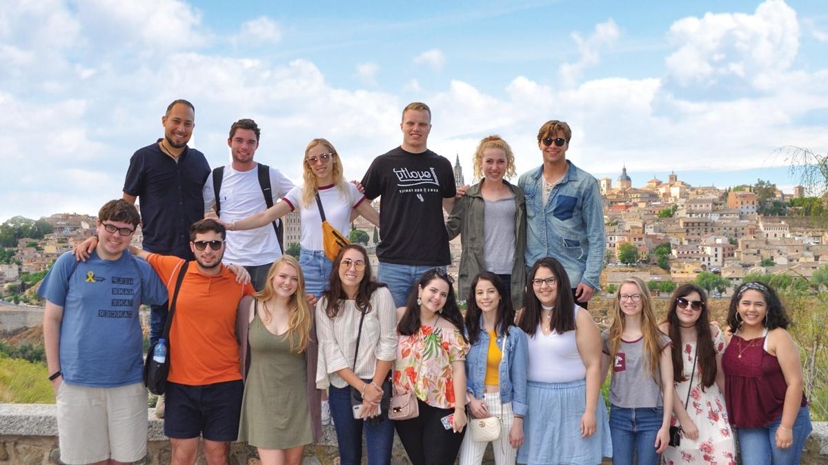 a group photo posed in front of the background of historic Madrid Spain